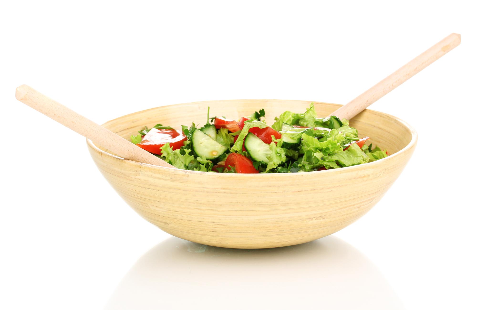 Bright salad bowl on wooden board